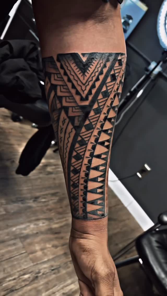 Bold geometric Polynesian tribal forearm sleeve with sharp chevrons