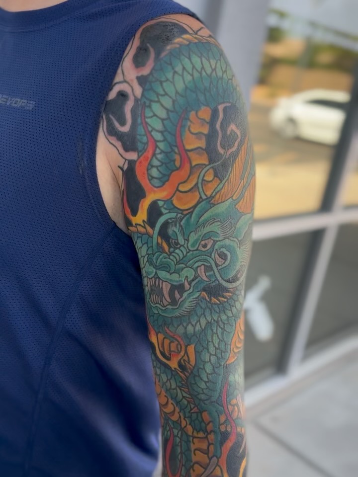 Vibrant Japanese dragon sleeve with teal scales and flames