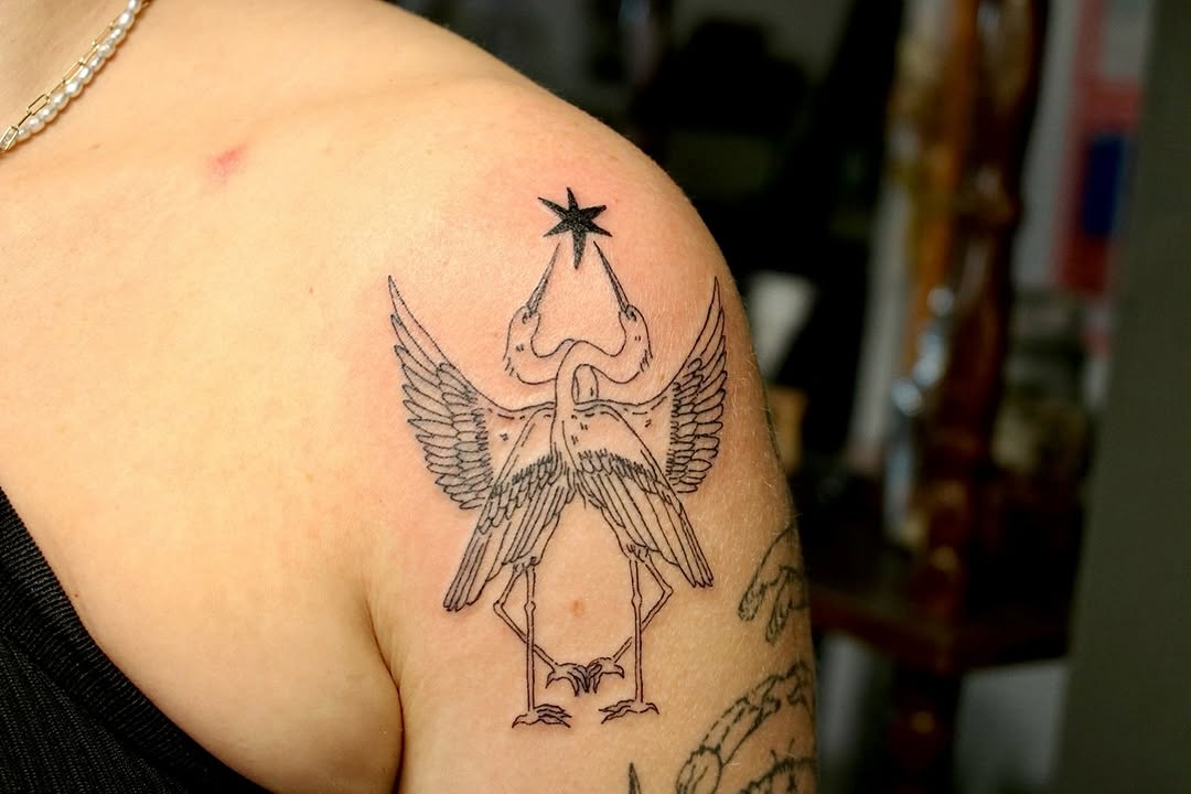 Delicate fineline heron with outstretched wings and star above