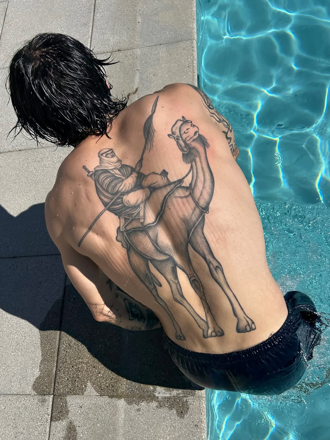 Bold black-and-gray camel and rider, dramatic back piece