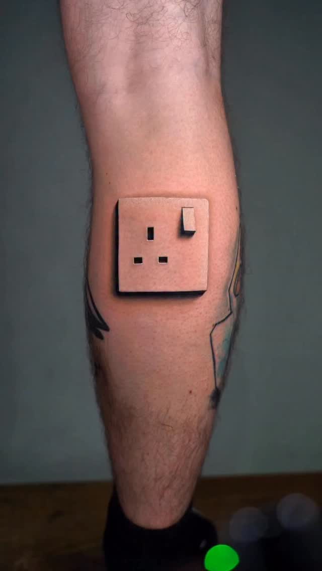 3D-style UK plug socket tattoo on calf
