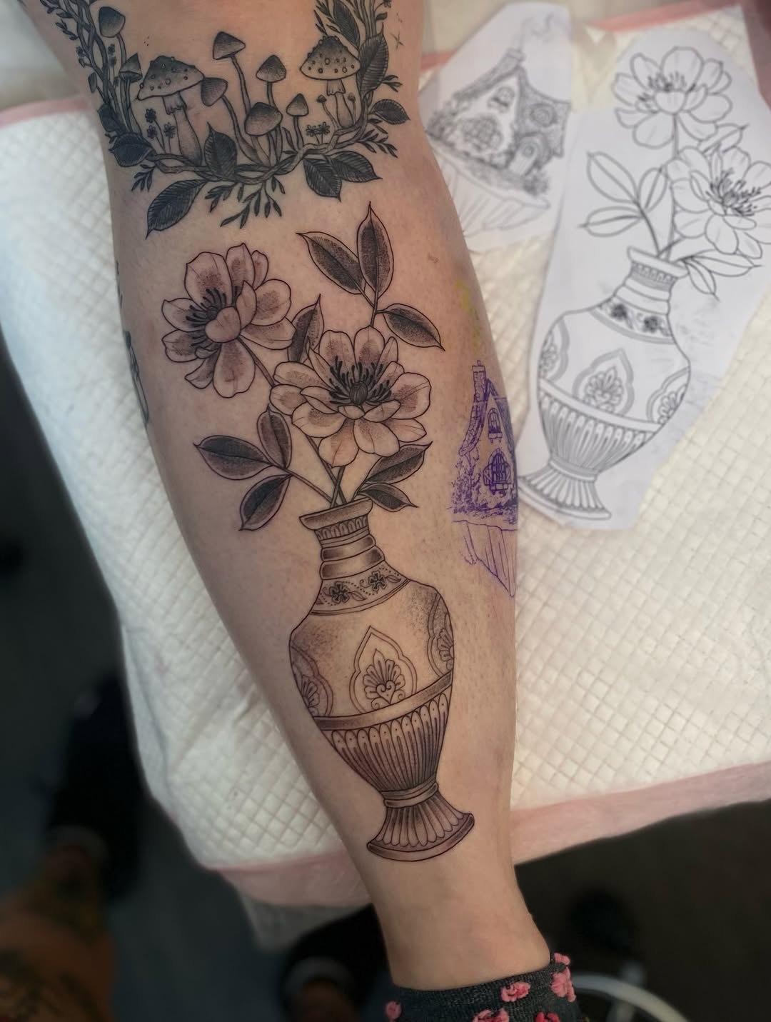 Elegant black-line vase with blooming flowers on calf