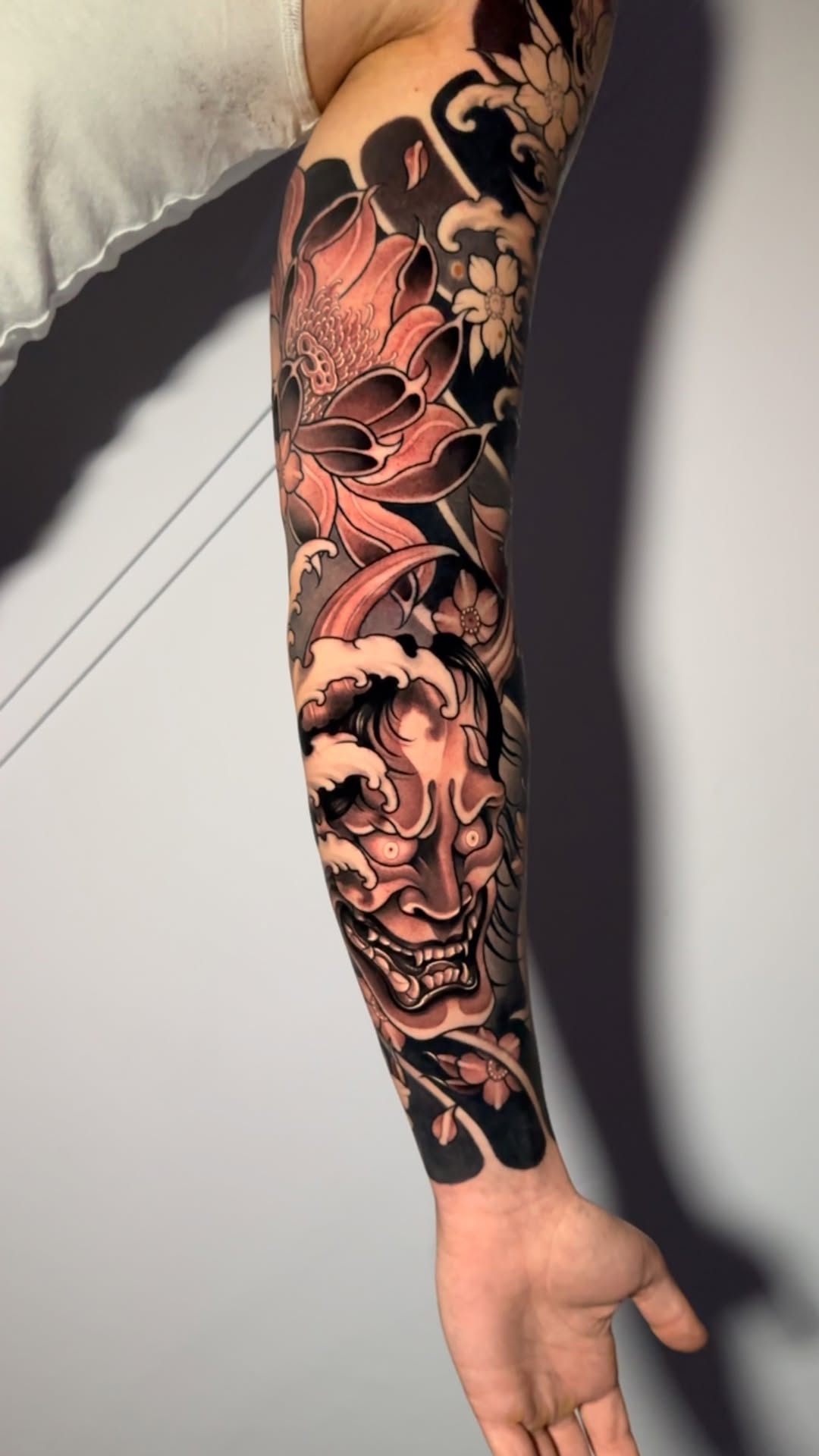 Intricate Japanese sleeve: fierce Hannya mask with lotus and sakura
