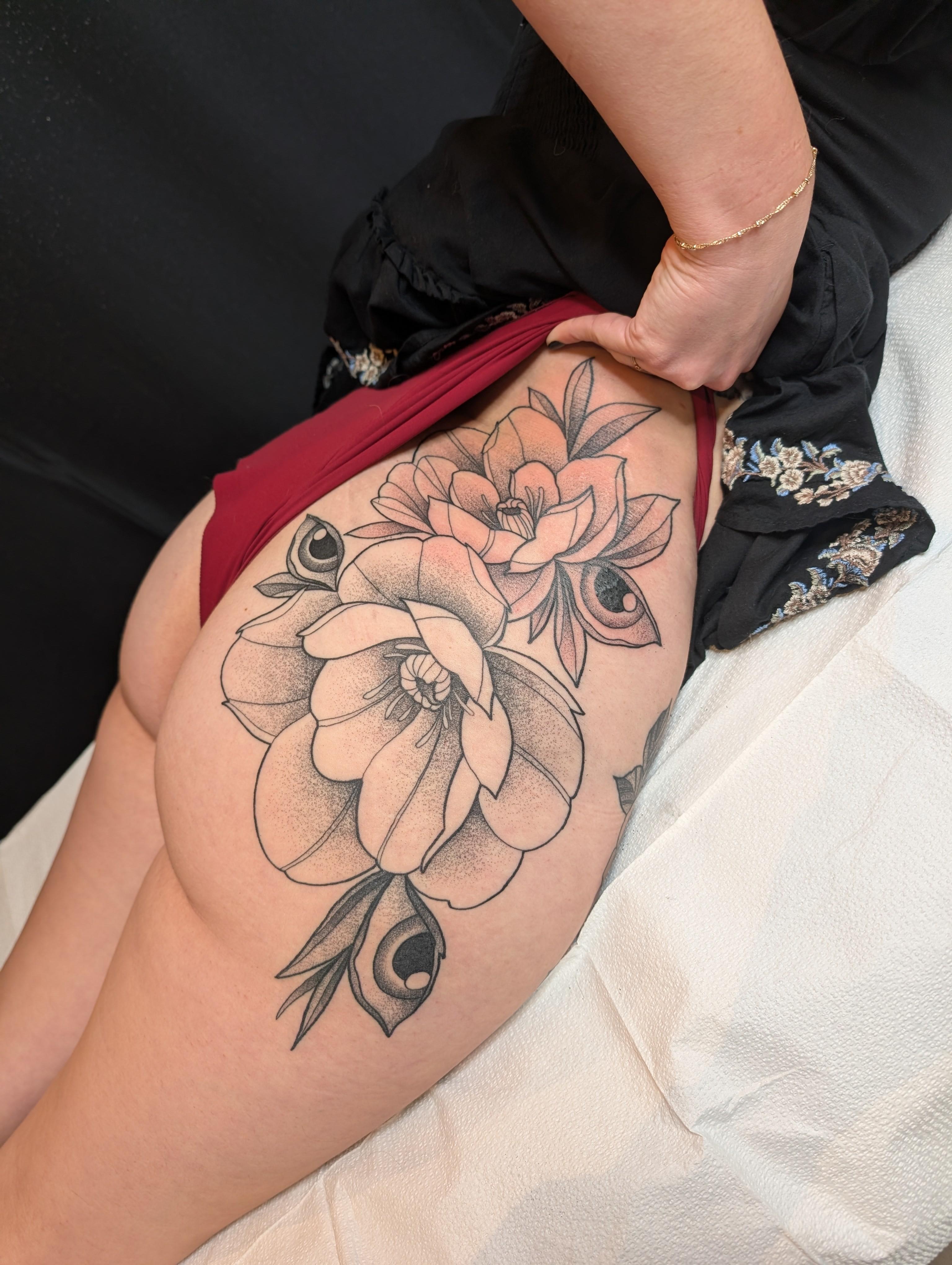 Bold black floral bouquet with dot-shaded petals along the outer thigh