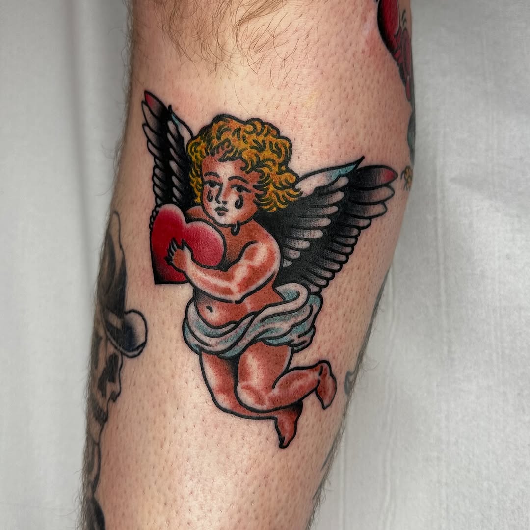 Bold traditional cherub with wings holding a red heart