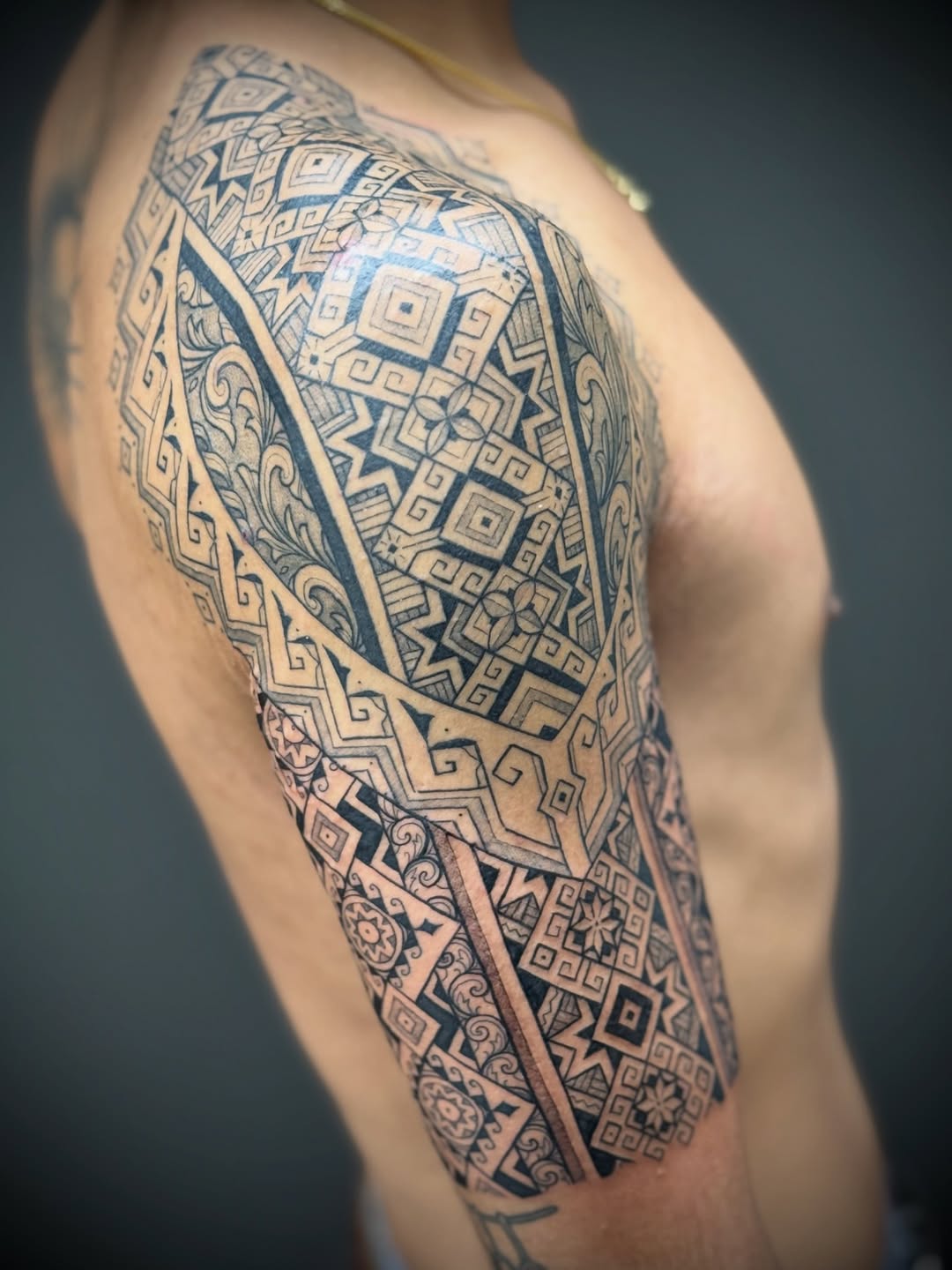Intricate blackwork geometric half-sleeve with ornamental motifs.