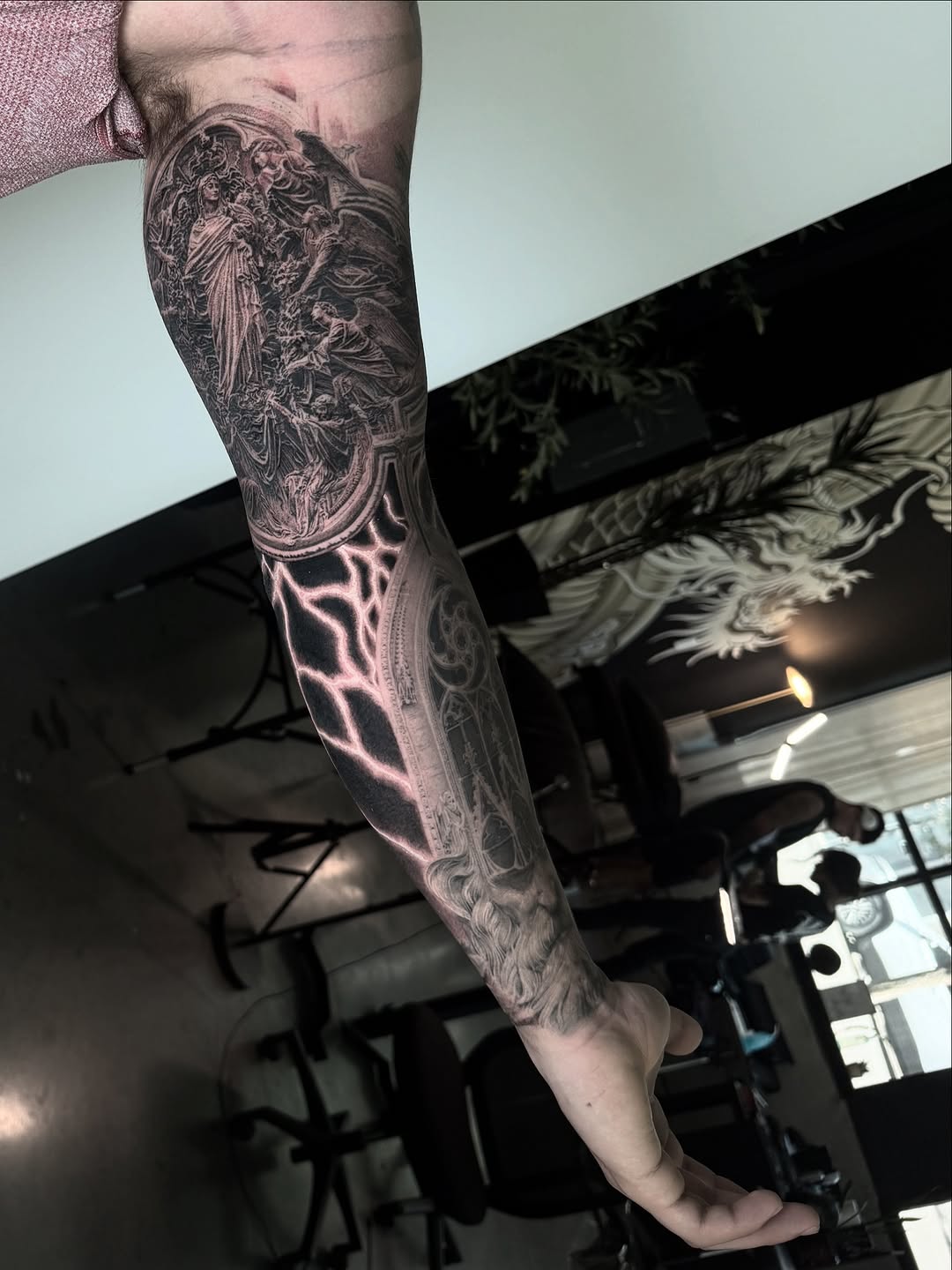 Hyper-detailed black-and-gray religious realism forearm sleeve