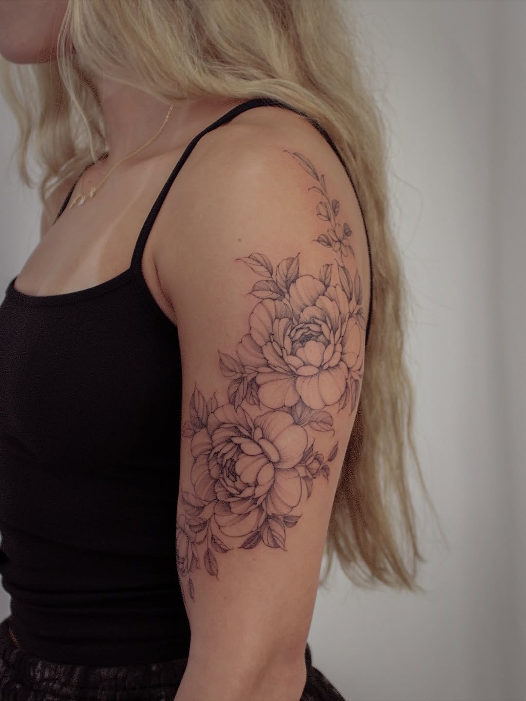 Delicate blackline floral cluster on the upper arm