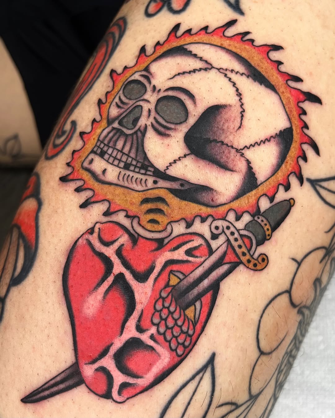 Bold traditional heart with dagger under skull sun