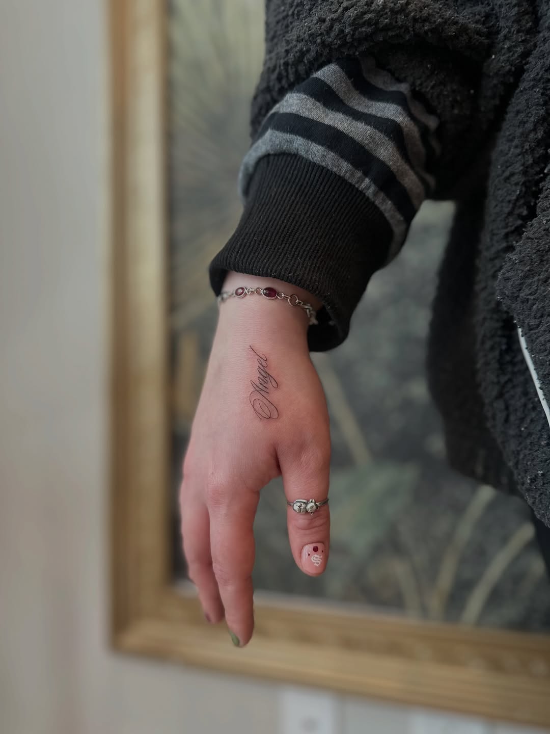 Delicate calligraphy script 'Magic' along the wrist