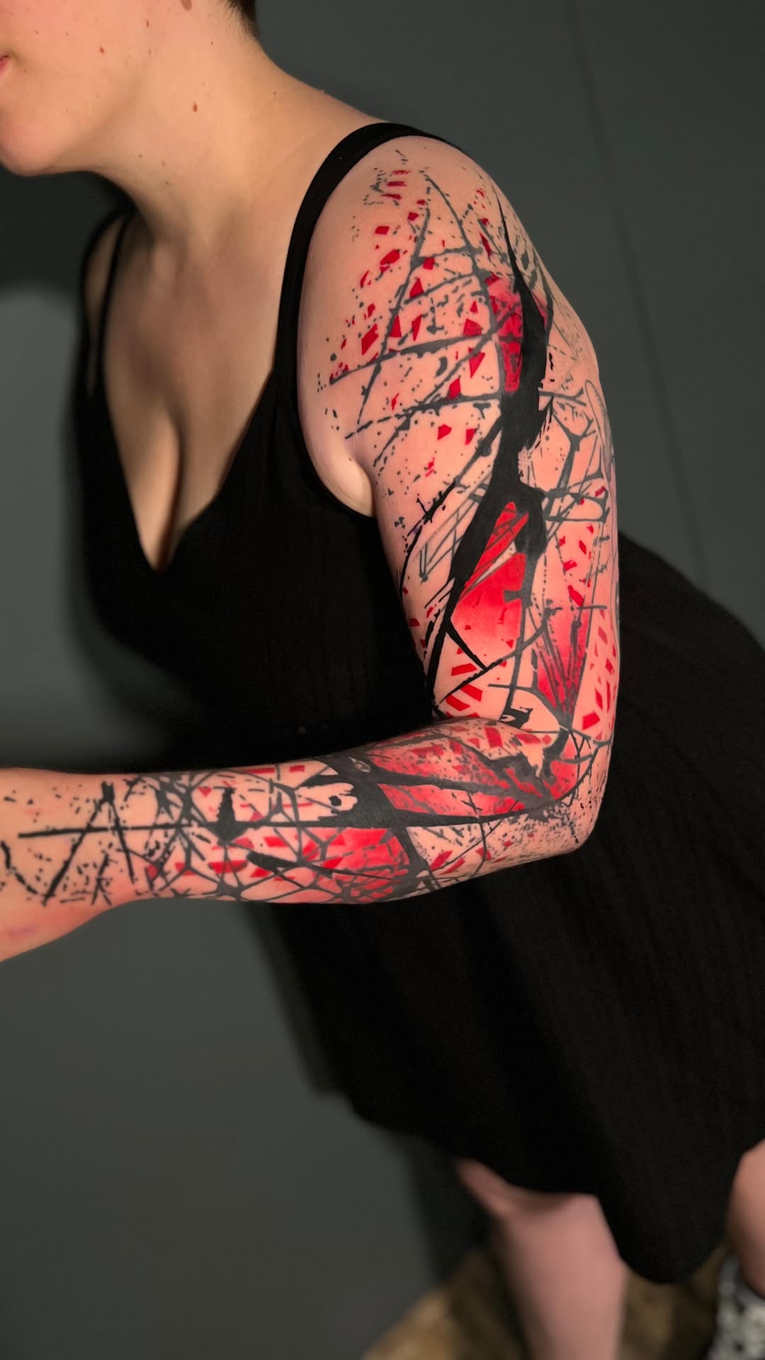 Bold abstract geometric sleeve with jagged black lines and red accents