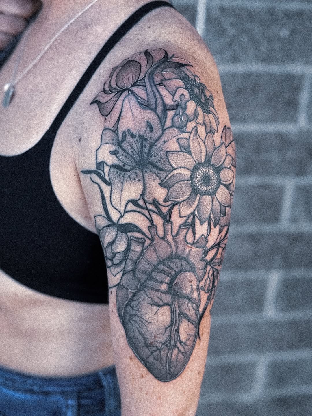 Bold blackwork floral sleeve with sunflowers and lilies