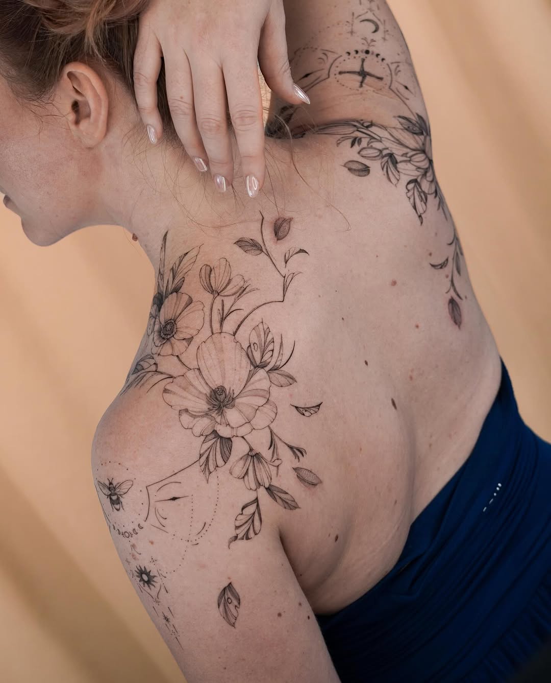 Delicate floral botanical piece wrapping shoulder, back and arm.