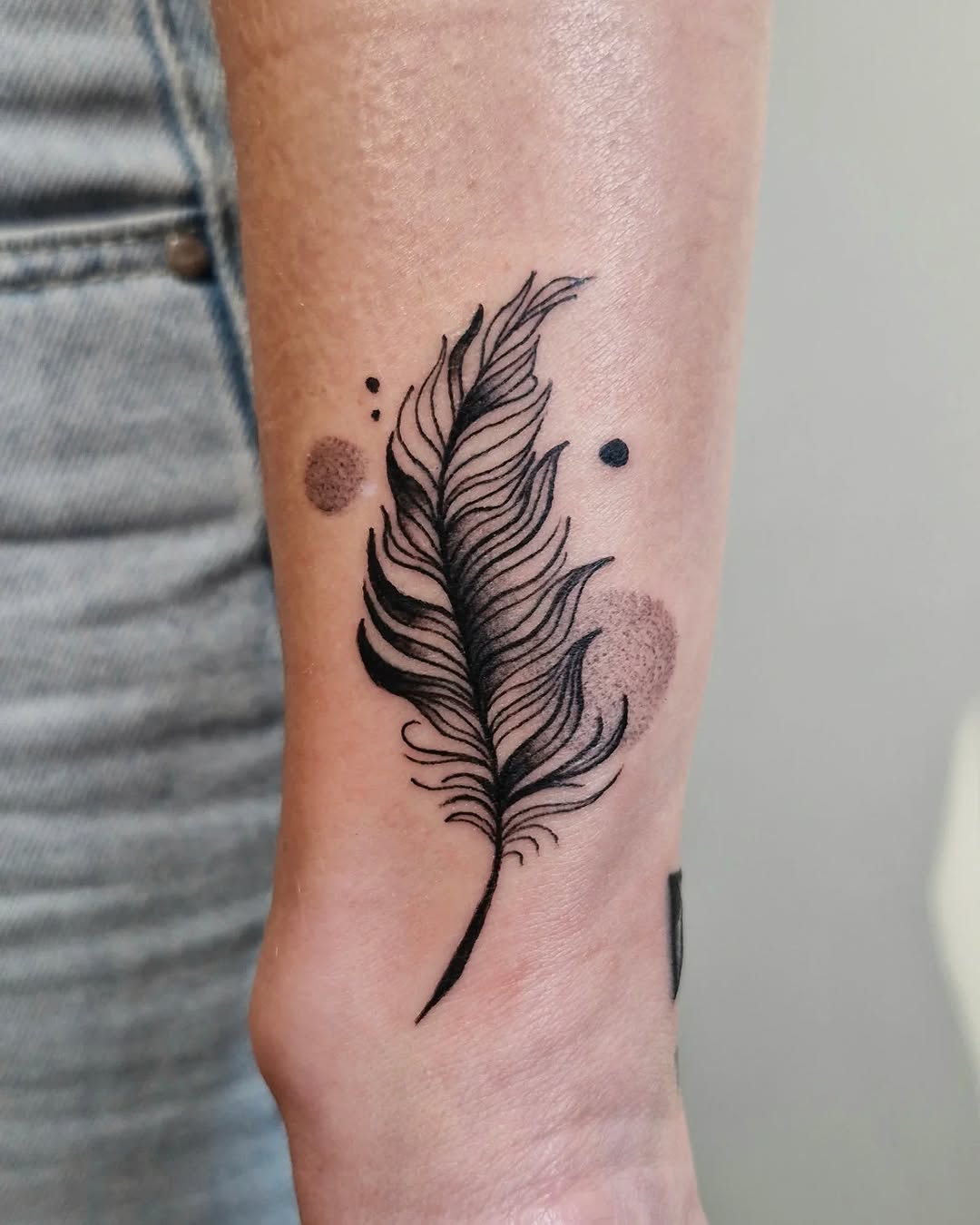 Elegant fineline feather with dotwork accents and bold shading