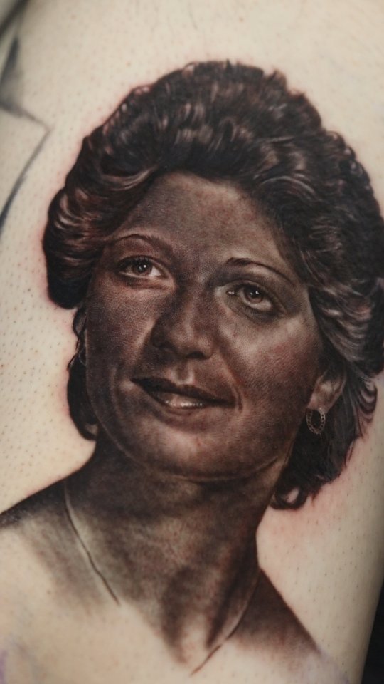 Hyper-realistic grayscale memorial portrait on the upper arm
