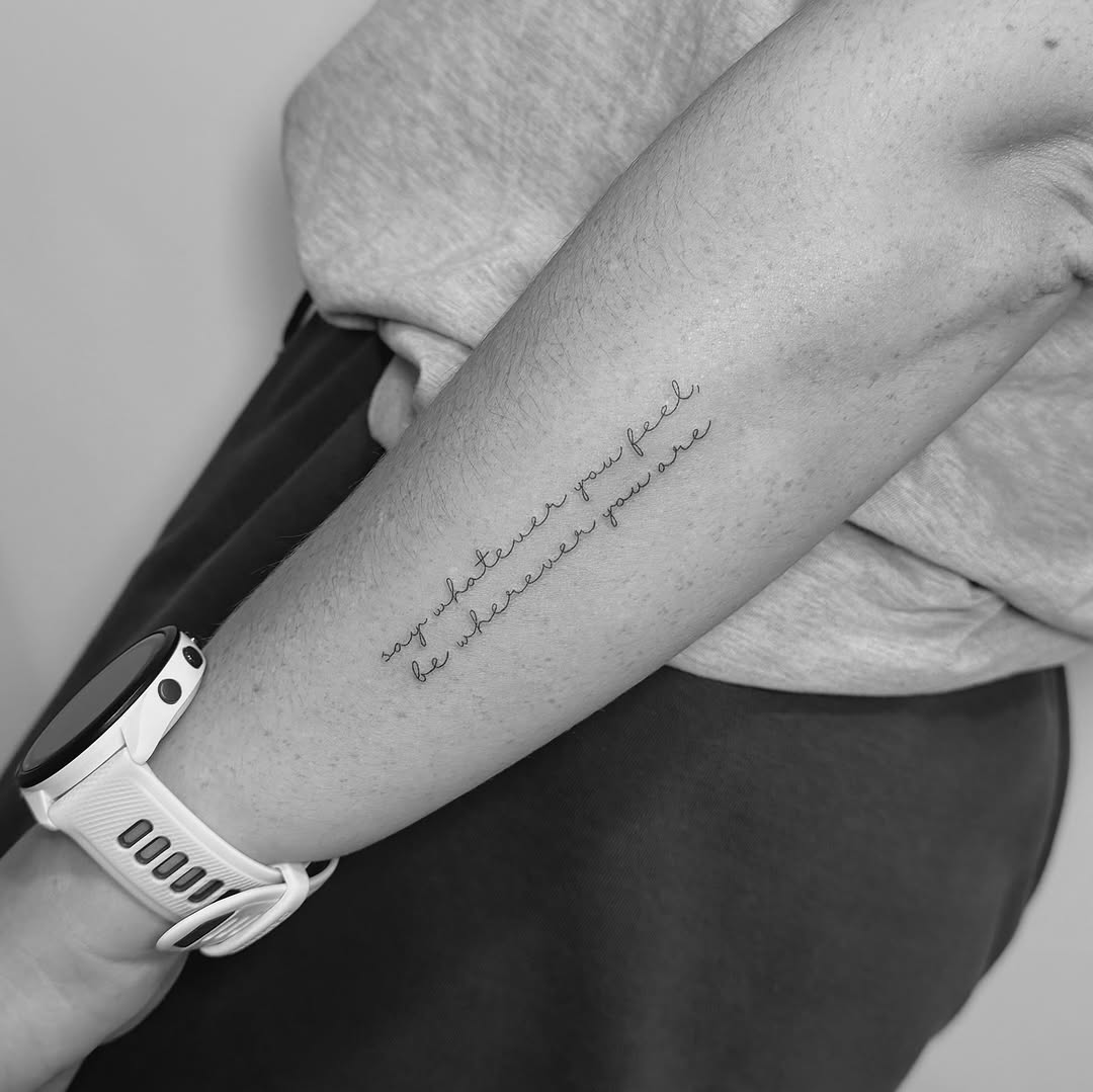 Elegant cursive quote along inner forearm in fine-line