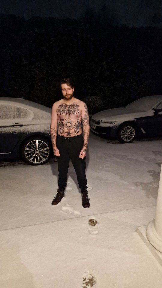 Shirtless man showcases bold blackwork across chest and arms.