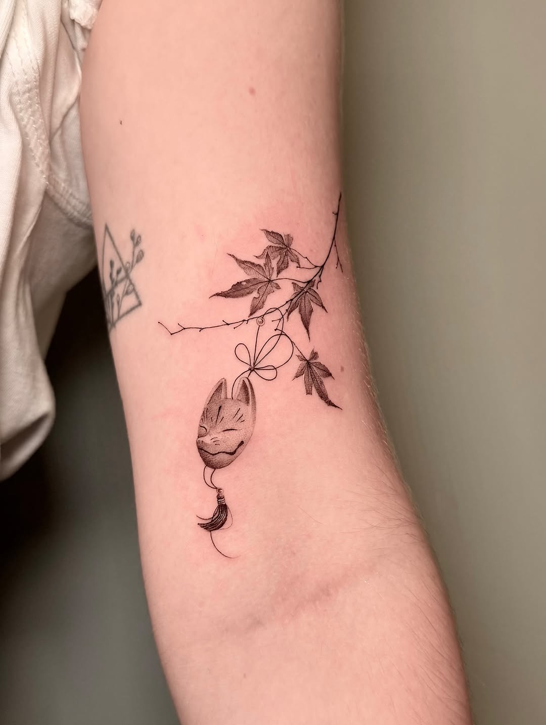 Delicate fineline vine with ivy leaves and hanging cat-face pendant