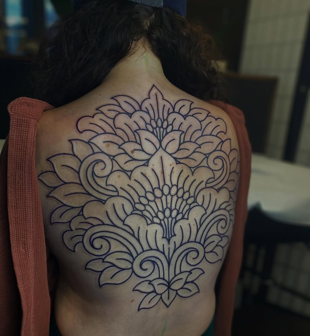 Intricate ornamental floral back piece in bold linework.