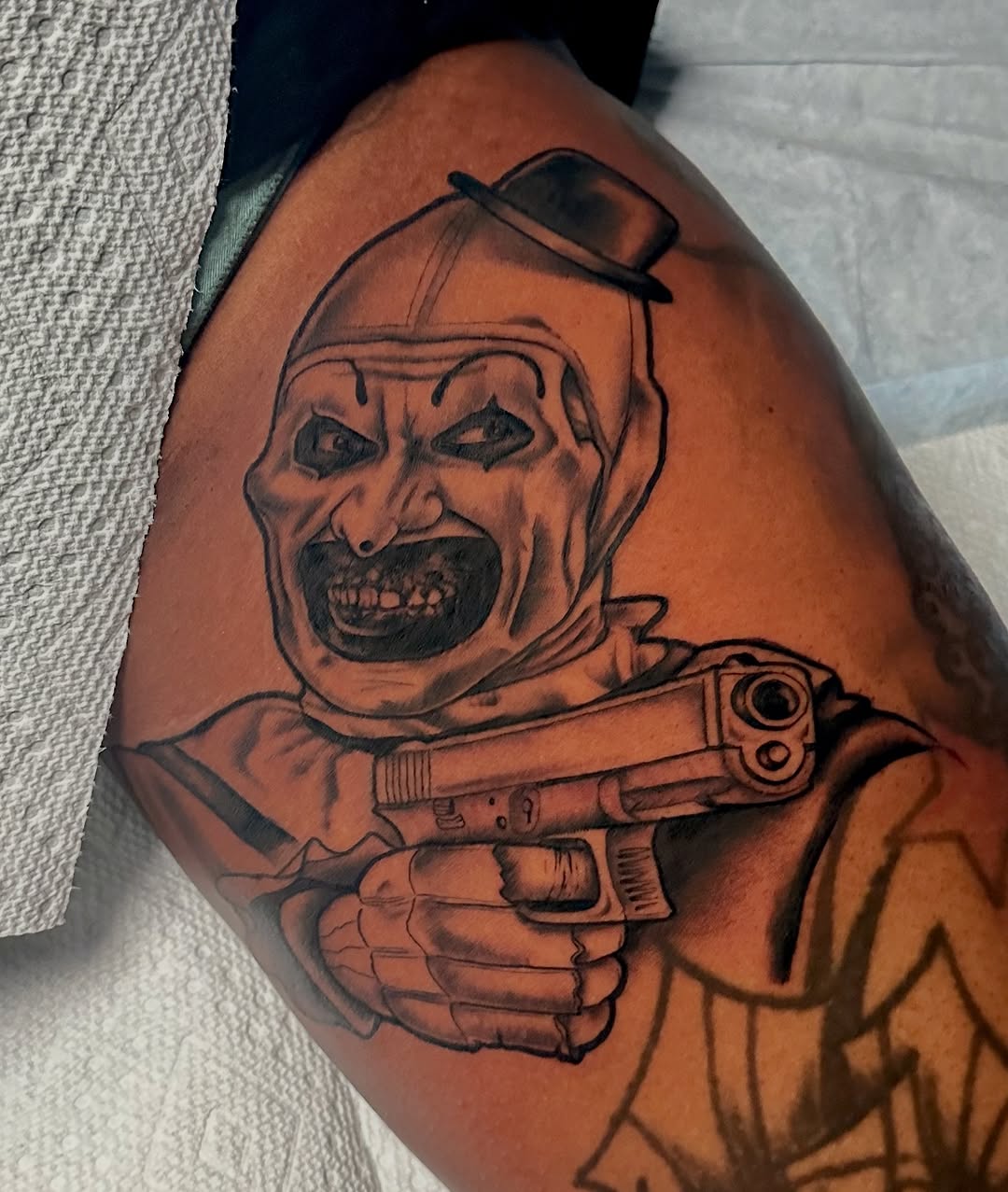 Menacing Art the Clown bust with gun in bold blackwork.