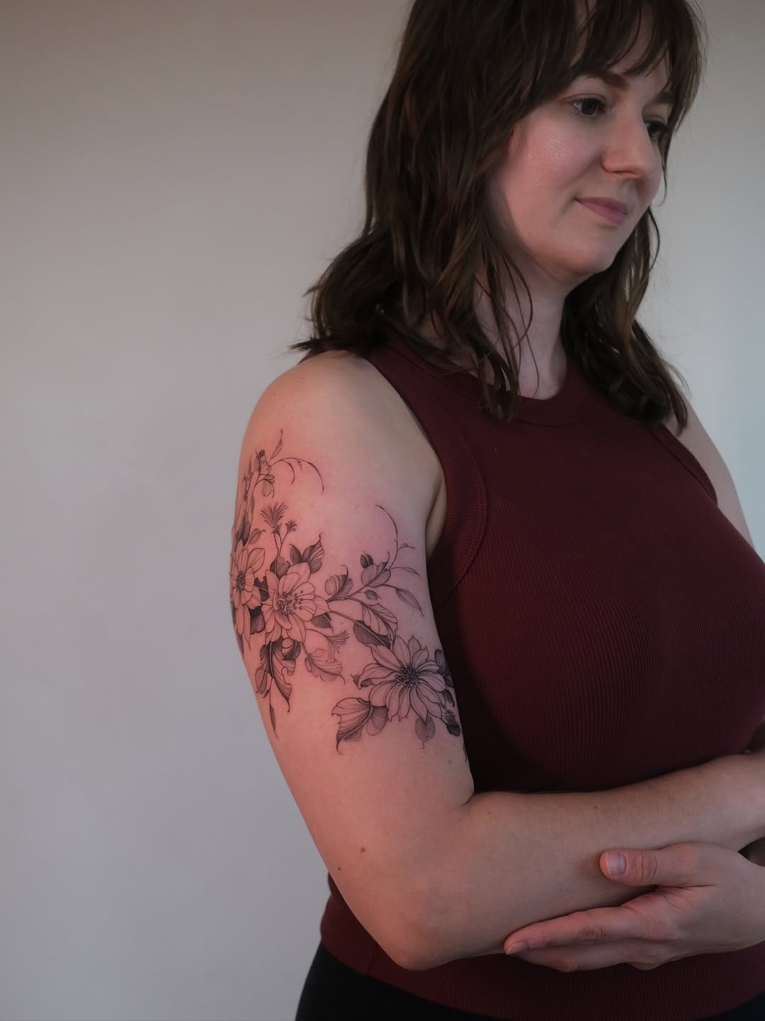 Delicate fine-line floral sleeve wrapping the upper arm.