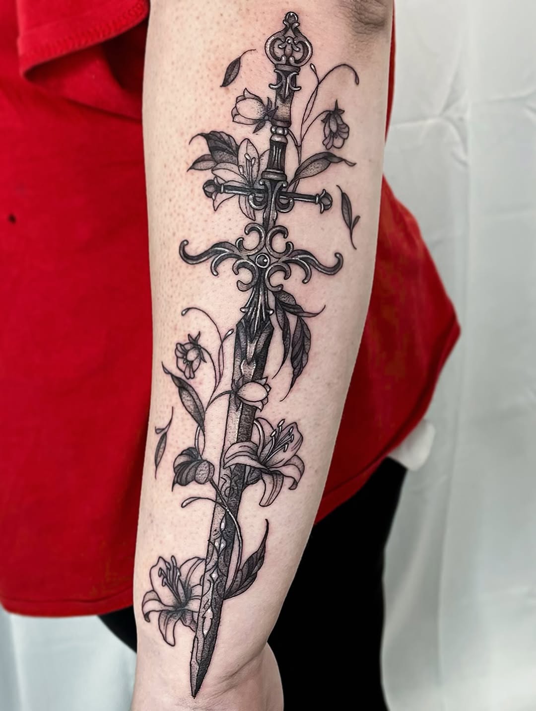 Ornate dagger pierced by entwined blooming vines and leaves