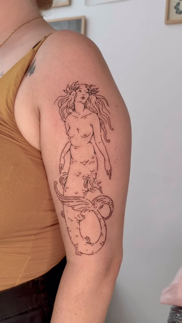 Delicate mermaid linework with flowing hair and tail
