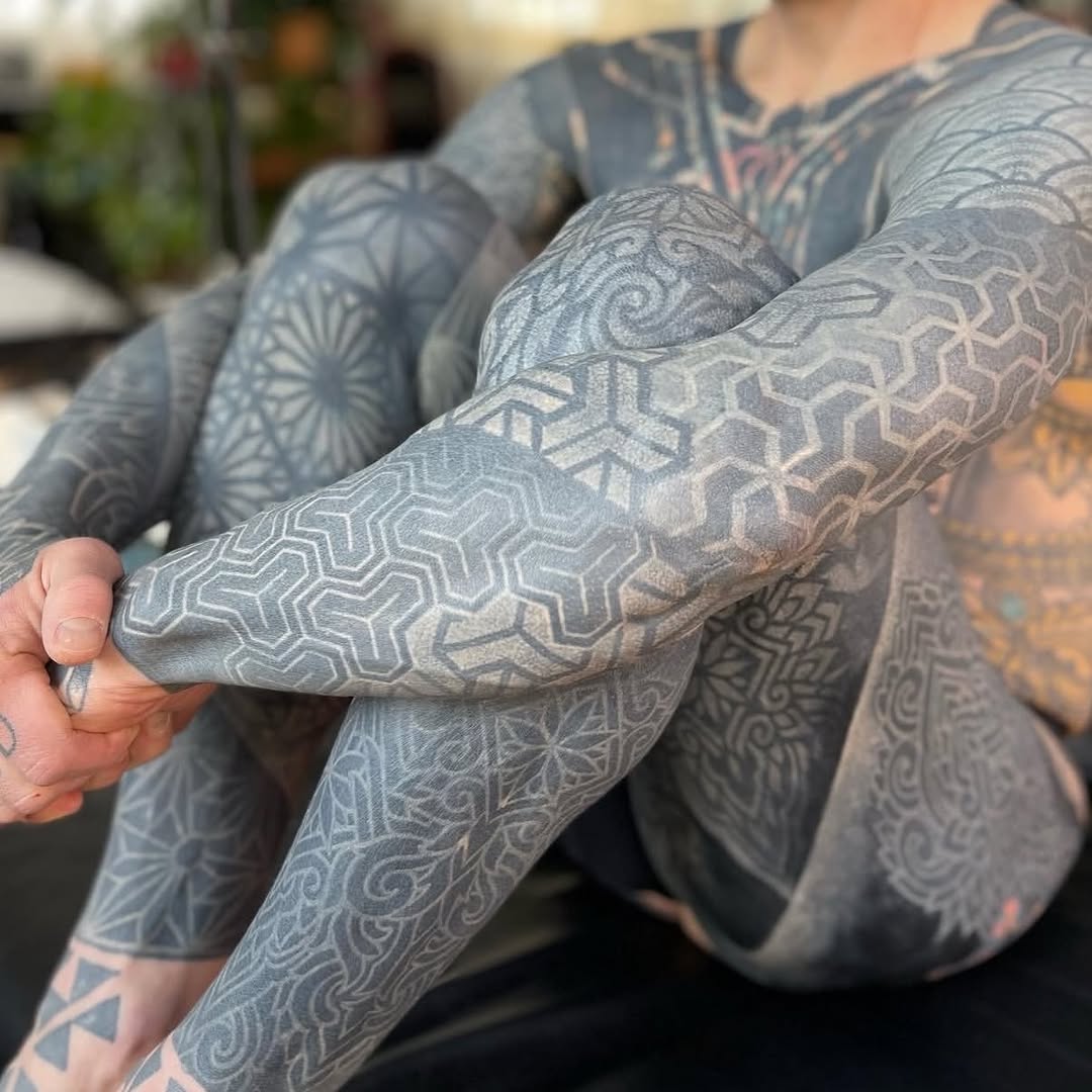 Intricate geometric dotwork sleeve spanning arms and chest