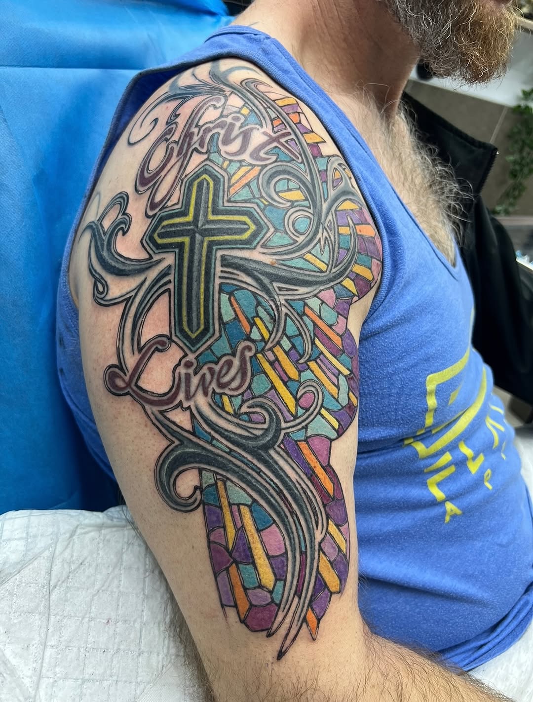 Vivid stained-glass cross with flowing script