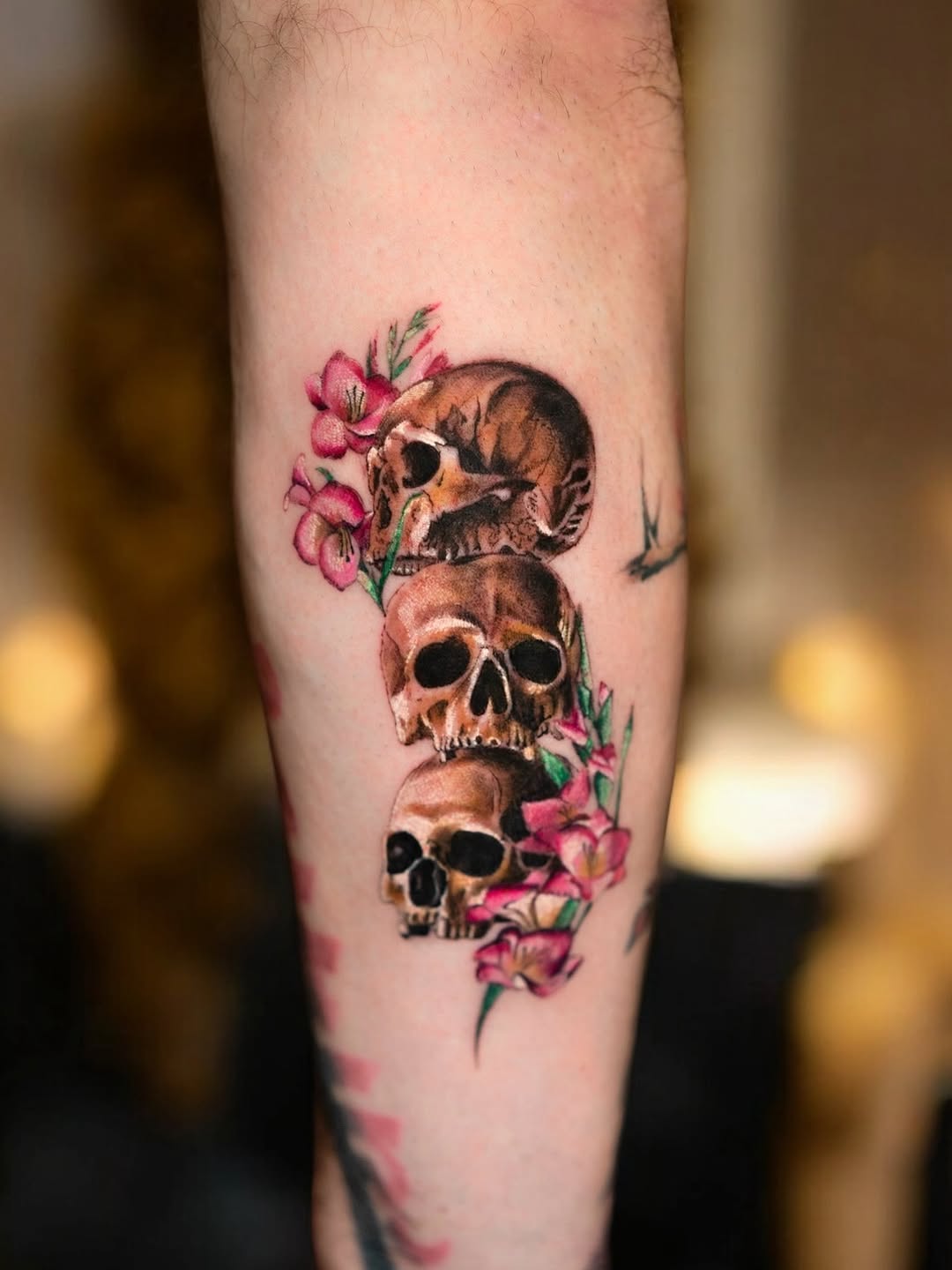 Vivid skulls intertwined with pink blossoms, lush realism.