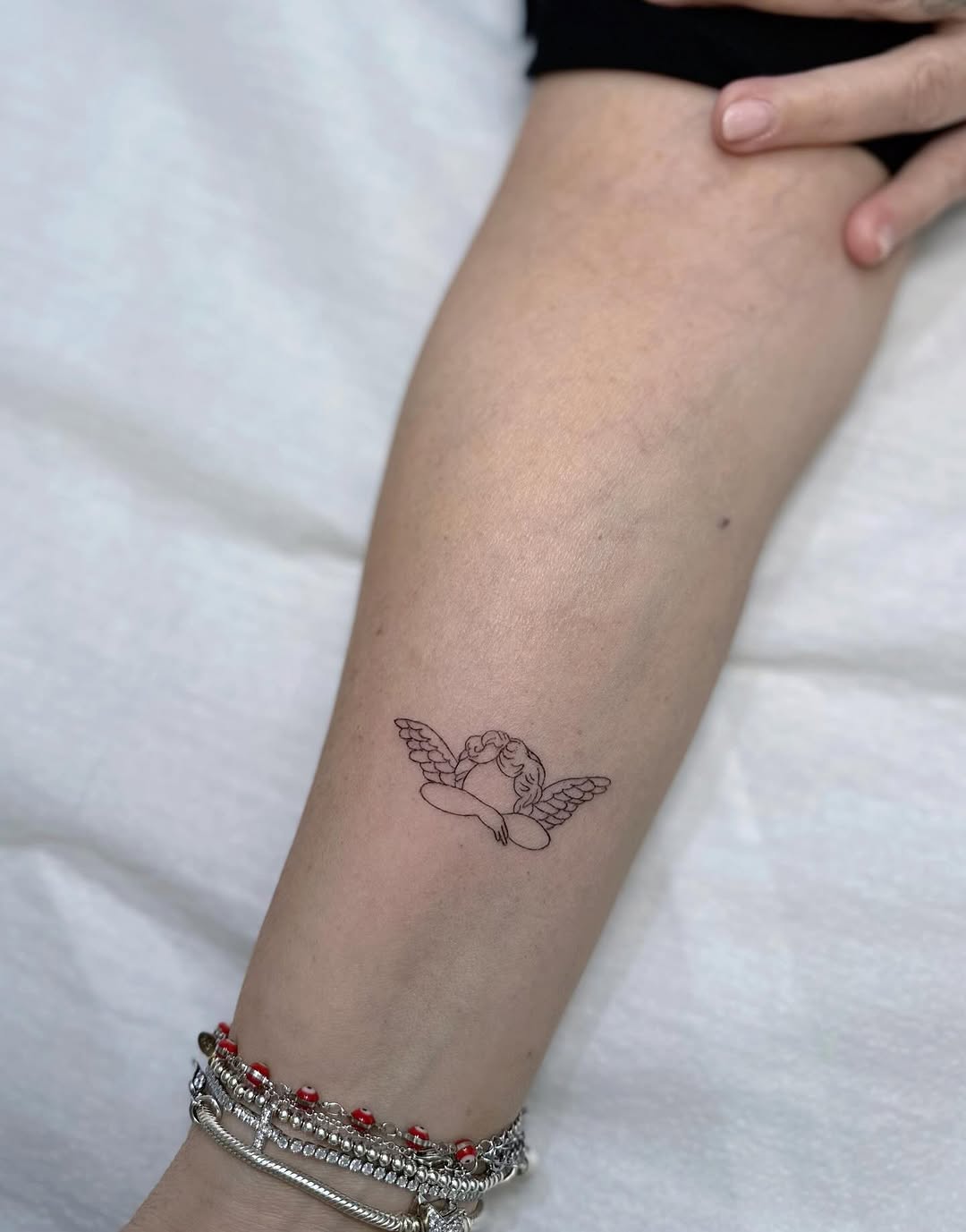 Delicate fine-line cherub with outstretched wings