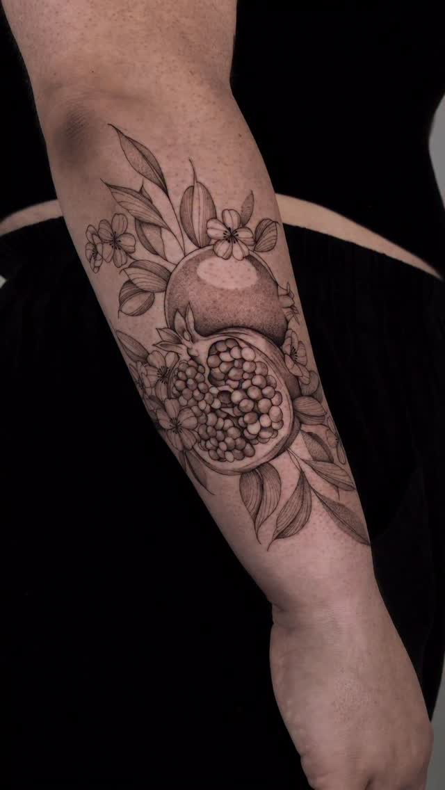 Intricate pomegranate half with seeds and blossoms