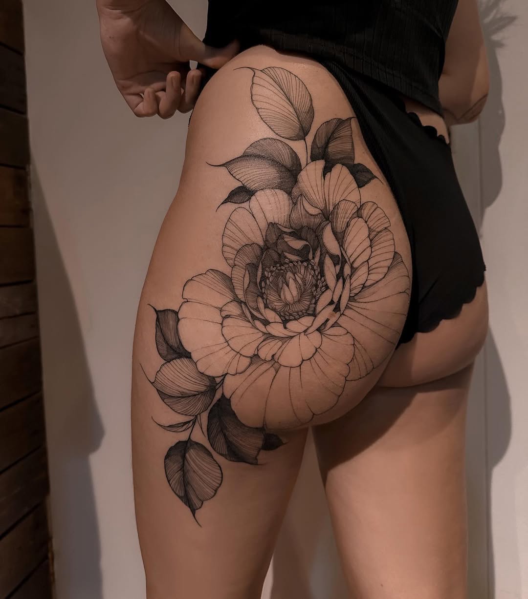 Intricate blackline peony with flowing leaves on thigh