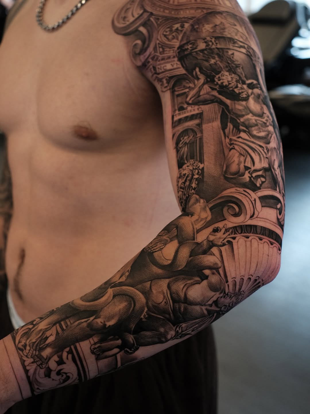 Intricate black-and-gray baroque sleeve featuring classical sculptures