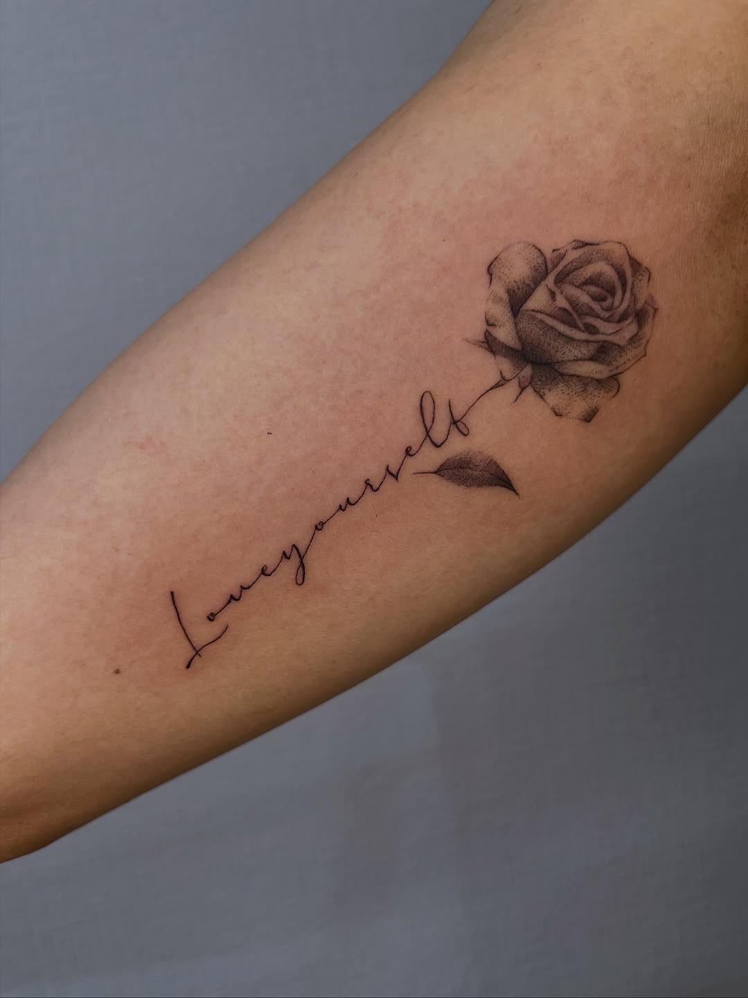 Delicate fine-line rose with cursive 'love yourself' script