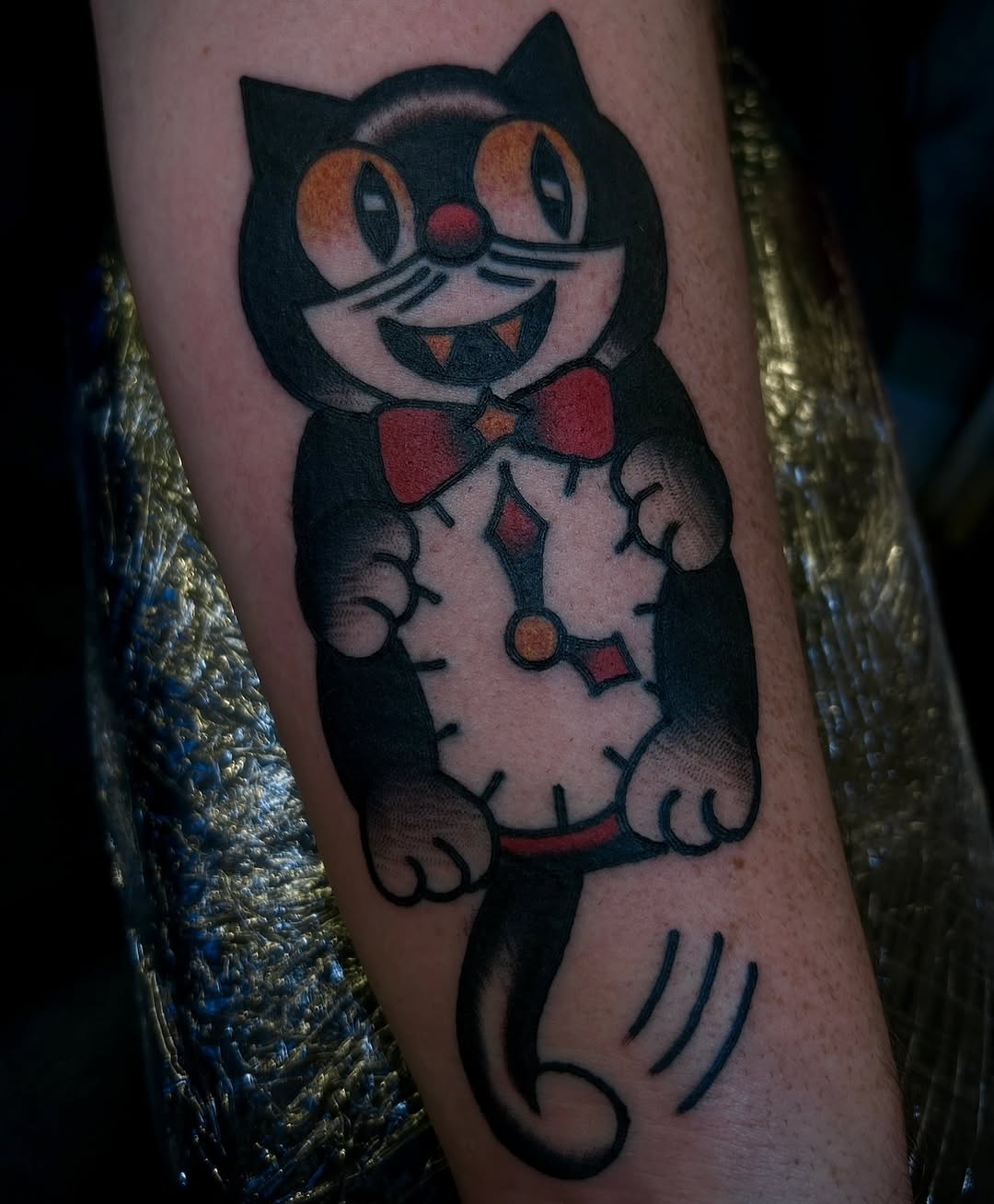 Bold cartoon cat in tuxedo with red bow tie.