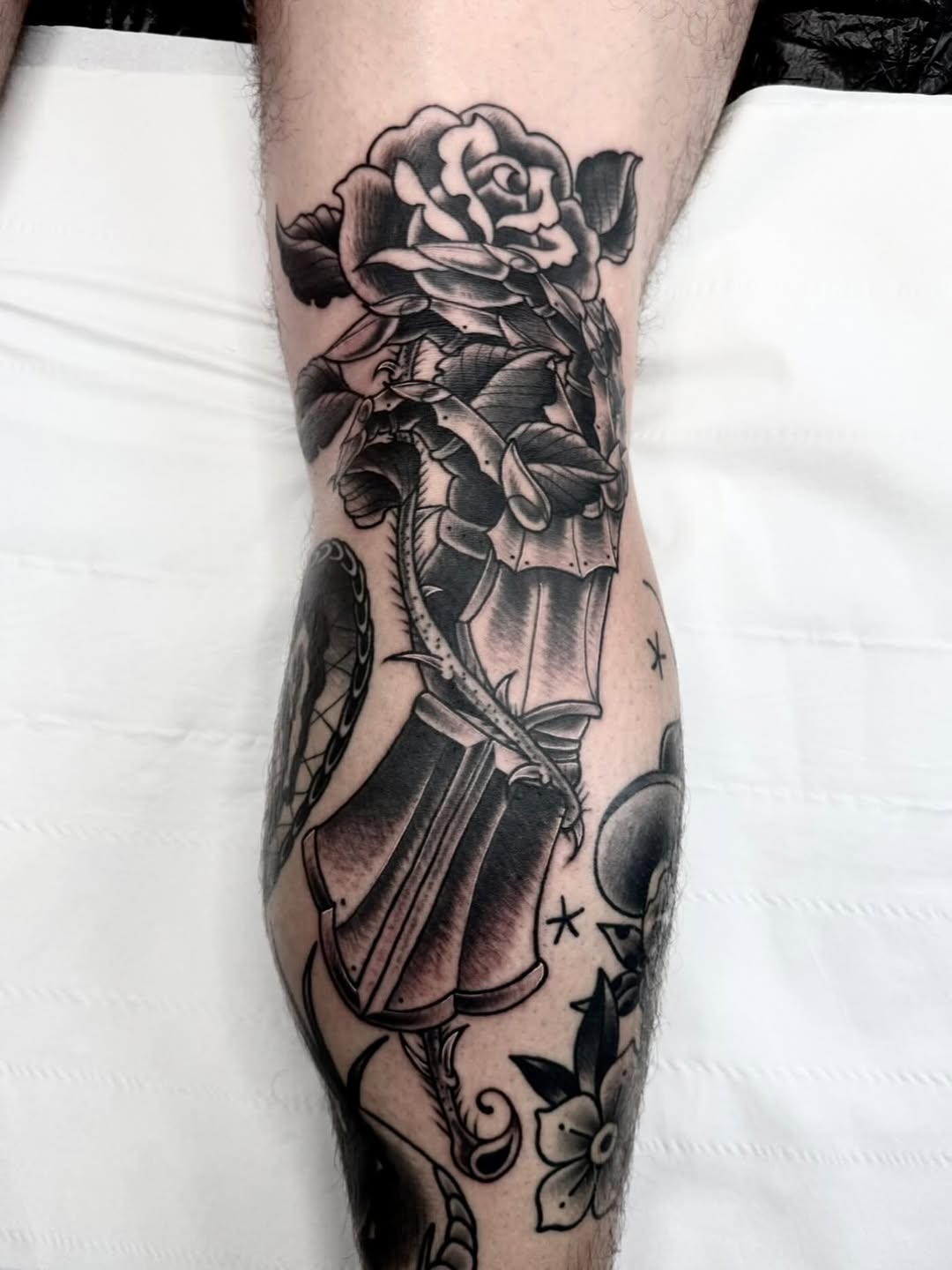 Sleek black-and-gray gauntlet cradling a blooming rose