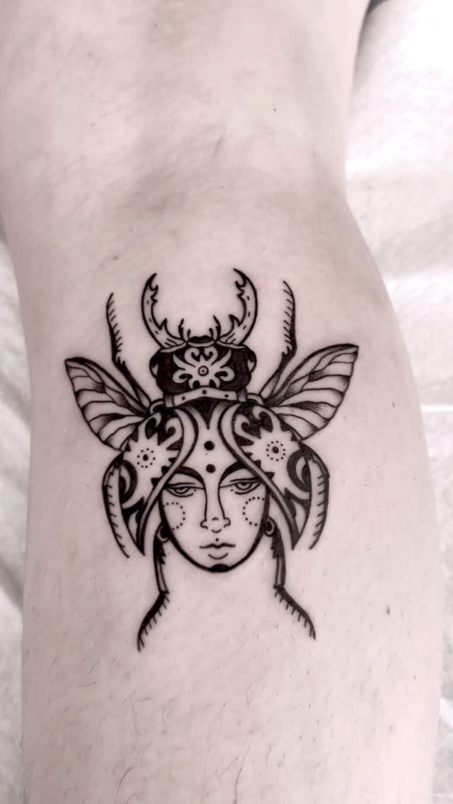 Intricate blackwork beetle-queen head with ornamental motifs