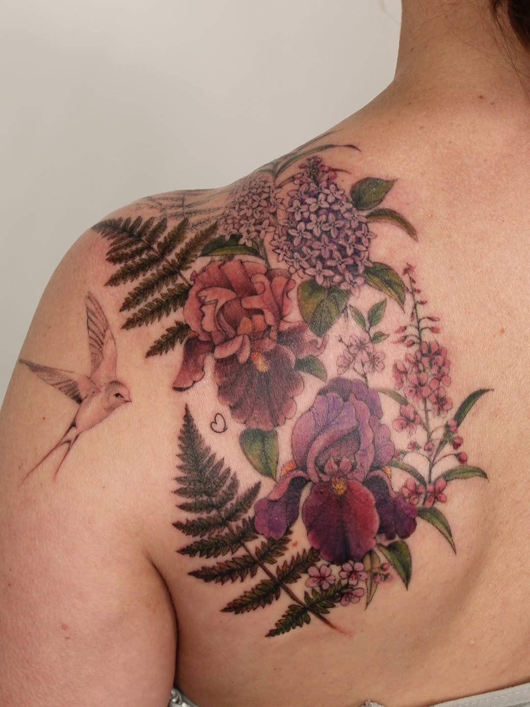 Vibrant botanical shoulder piece with roses, hydrangea, ferns, hummingbird