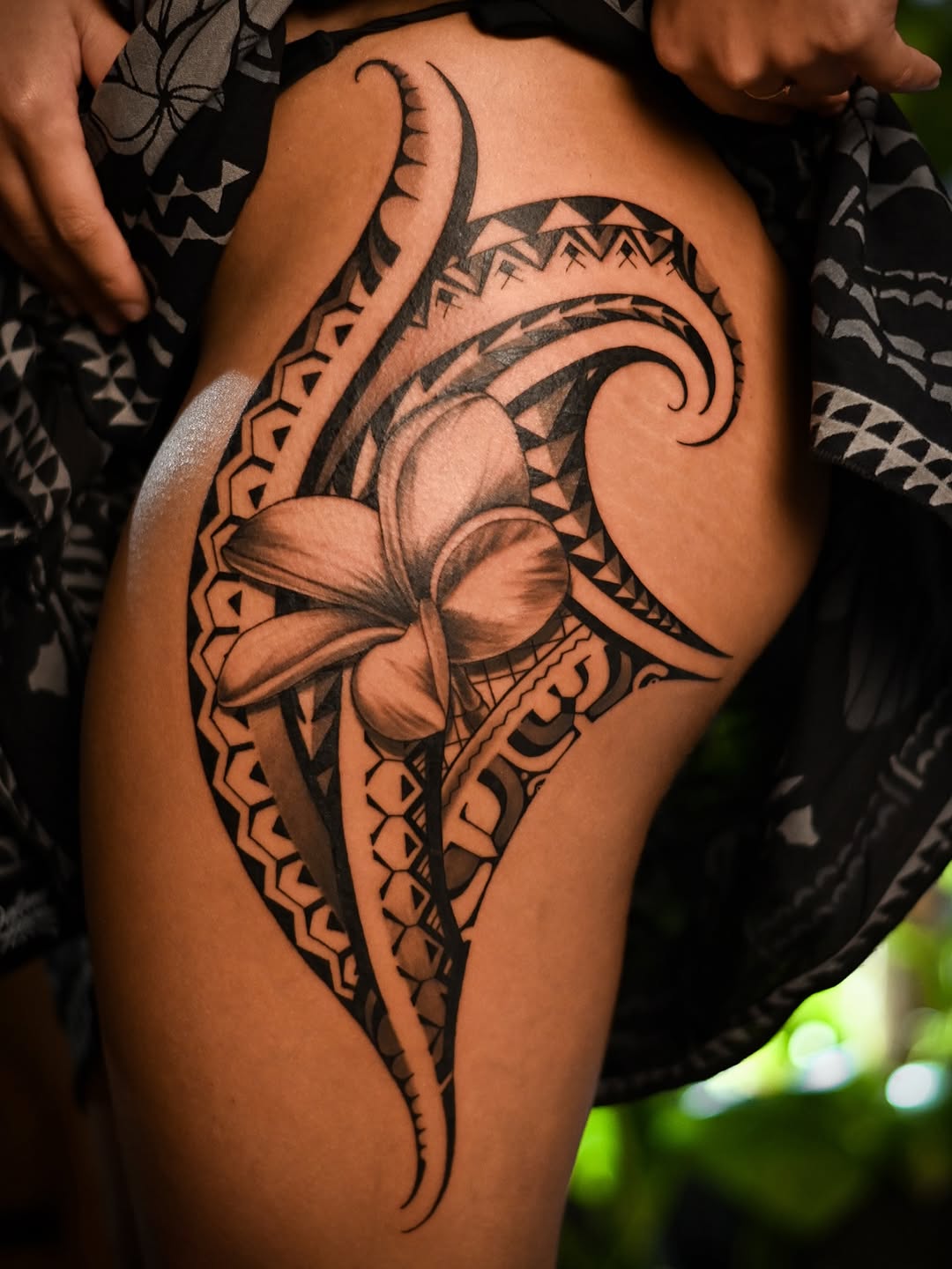 Bold Polynesian floral with geometric blackwork on thigh