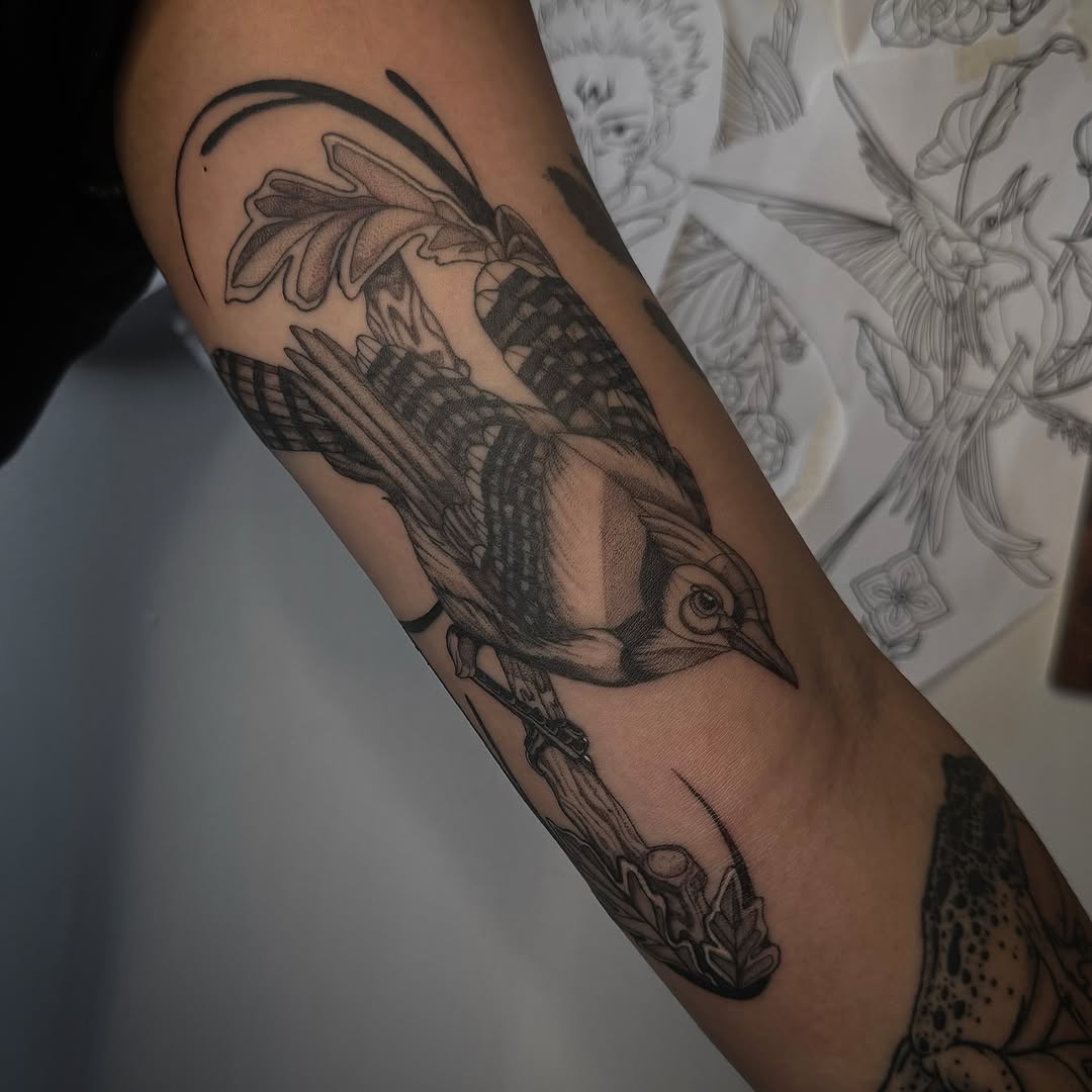 Intricate blackwork bird with bold linework on forearm