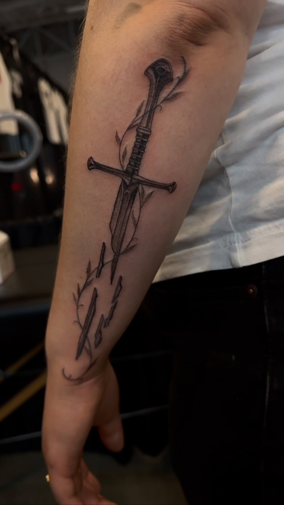 Sleek blackwork sword entwined with delicate vines