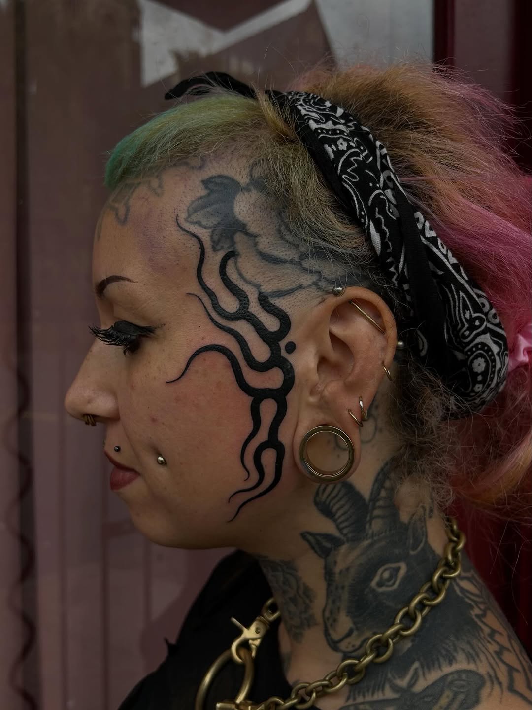 Bold blackwork temple-to-neck tattoo with organic waves