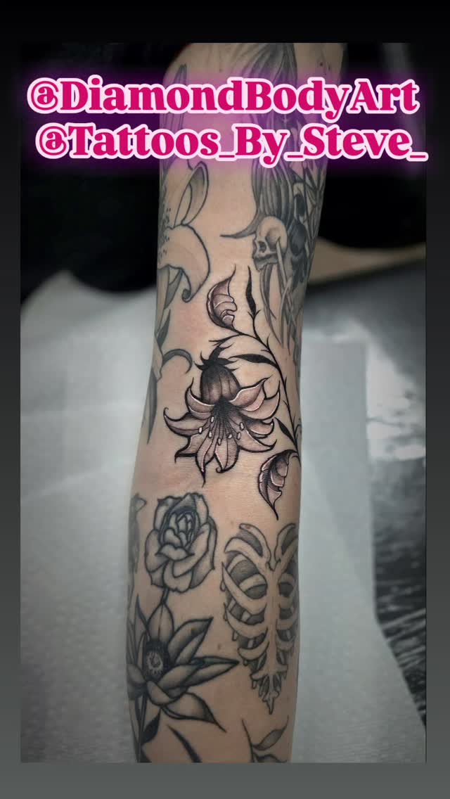 Intricate black-and-gray floral sleeve with lilies and roses