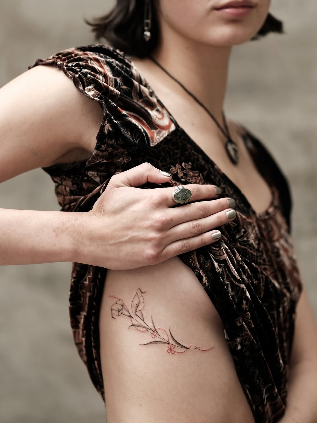 Delicate botanical vine with fine linework and red accents