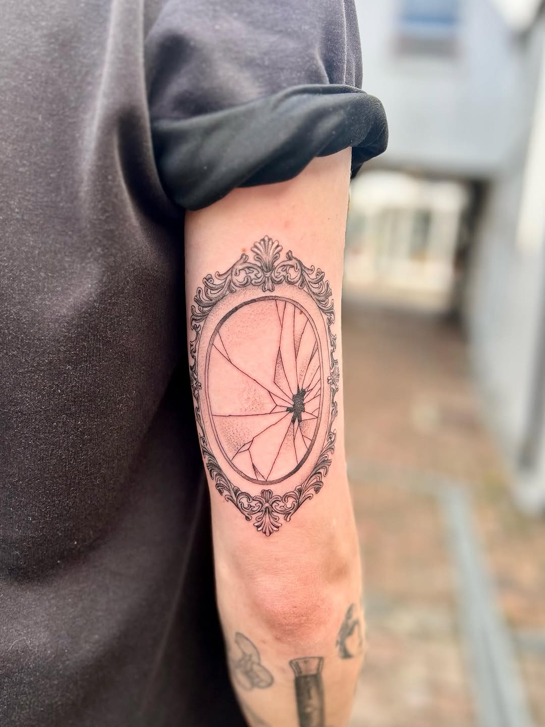 Ornate baroque oval frame surrounding shattered mirror shards