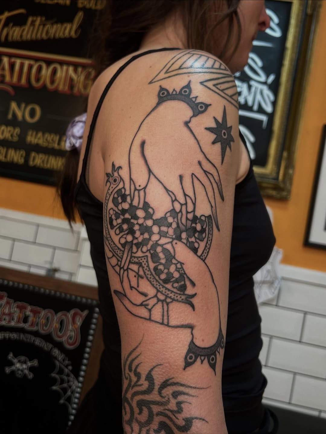 Bold blackwork bird perched over an abstract bead cluster