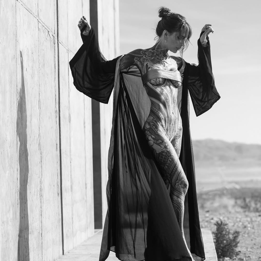 Ethereal blackwork bodysuit tattoo across torso and legs.