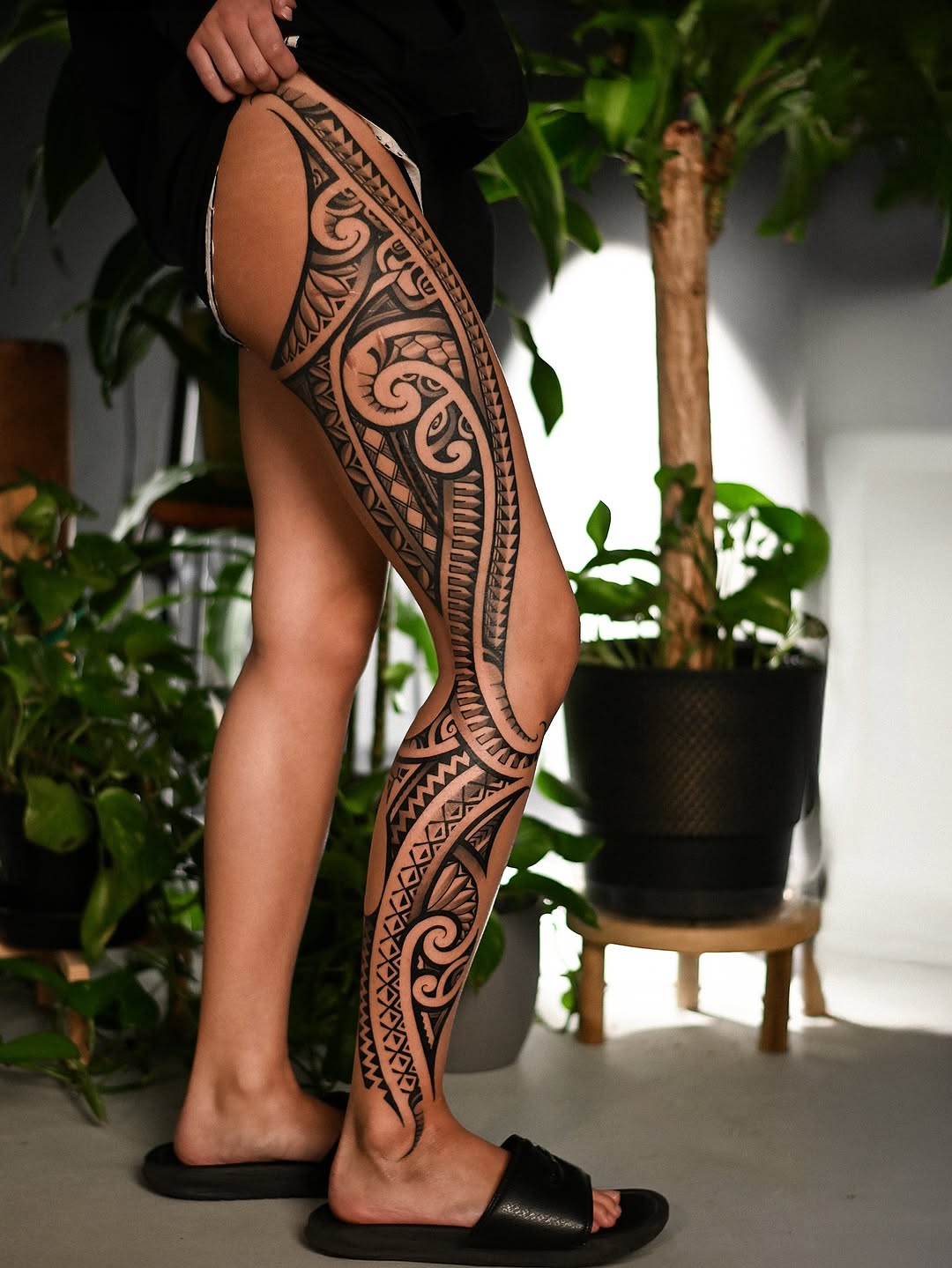 Bold Polynesian tribal leg sleeve in blackwork with geometric patterns