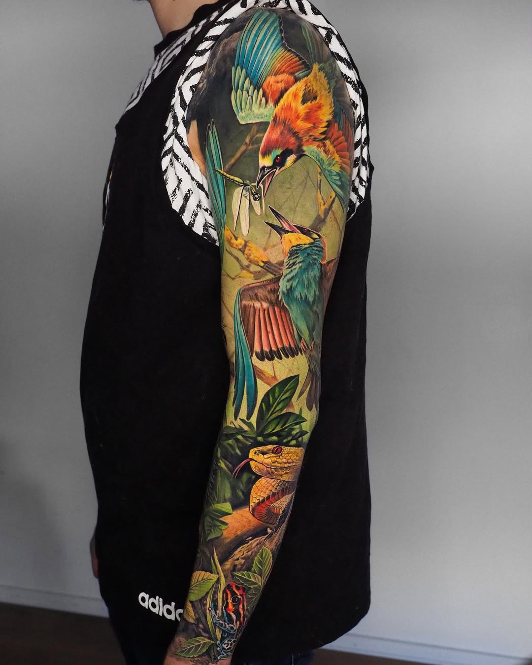 Vivid tropical bird sleeve with vibrant snakes and foliage